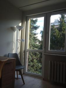 um quarto com uma janela com uma cadeira e uma secretária em U Cioci em Cracóvia