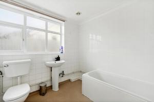 a white bathroom with a toilet and a sink at Beautiful Boutique Derbyshire Abode - Games room in Derby