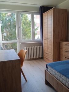 um quarto com uma cama, uma secretária e janelas em U Cioci em Cracóvia
