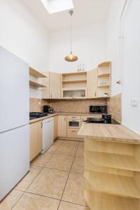 a kitchen with white cabinets and a white refrigerator at Venus Apartments - Opera II in Budapest