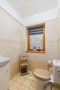 a bathroom with a toilet and a window at Venus Apartments - Opera II in Budapest