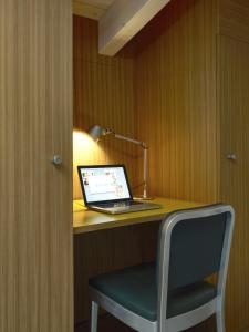 un ordinateur portable assis sur un bureau avec une chaise dans l'établissement B&B Sottotetto, à Reggio d'Émilie