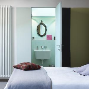 a bedroom with a bed and a sink and a mirror at B&B Sottotetto in Reggio Emilia