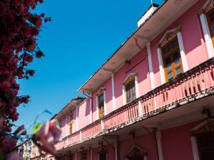 a pink building with windows and a balcony at Ibis Styles Phuket City in Phuket Town