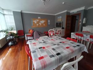 a dining room with a table and red chairs at A Barca de Pedra in Padrón