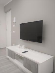 a white living room with a tv on a wall at Casa vacanze Venere in Balestrate