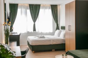 - une chambre avec un lit dans une pièce dotée de fenêtres dans l'établissement Sun Marco Apartments in Athens, à Athènes