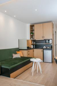 - un salon avec un canapé vert et une table blanche dans l'établissement Sun Marco Apartments in Athens, à Athènes