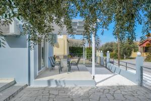 a patio with chairs and a table in a house at Nik-Ntin Villa Deluxe in Prinos