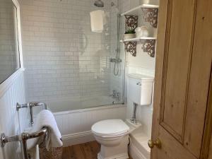 uma casa de banho com um WC, um chuveiro e uma banheira em Station House, Gilling em Gilling East