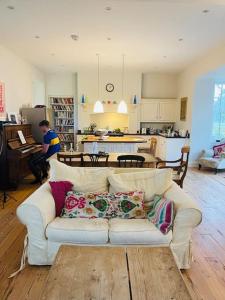 a living room with a white couch and a kitchen at Station House, Gilling in Gilling East