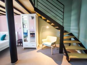 a room with a staircase and a chair and a mirror at Social Lodge - Happiness in Funchal