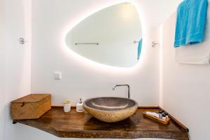 a bathroom with a stone sink and a mirror at MANI HOLIDAY HOUSE in Kotrónion