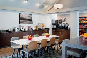 Residence Inn Dallas Las Colinas في ايرفينغ: غرفة طعام مع طاولة وكراسي ومطبخ