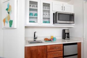 a kitchen with white cabinets and a sink and a microwave at Marriott's Harbour Lake in Orlando