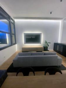 een woonkamer met een bank en een flatscreen-tv bij Nomads Hosting Alojamientos in Oleiros