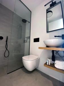 een badkamer met een toilet, een wastafel en een douche bij Nomads Hosting Alojamientos in Oleiros