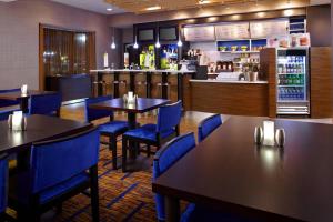 a restaurant with tables and chairs and a bar at Courtyard Newark Granville in Newark