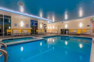 a pool at a hotel with tables and chairs at Fairfield Inn by Marriott Afton Star Valley in Afton