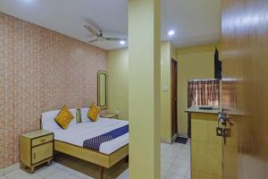 a bedroom with a bed and a bathroom with a mirror at SPOT ON Gayatri Lodge Near Snow World in Secunderabad