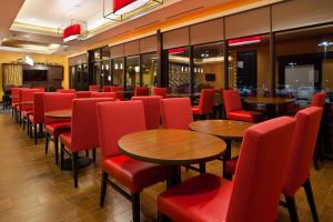 a restaurant with red chairs and tables and windows at TownePlace Suites by Marriott Carlsbad in Carlsbad