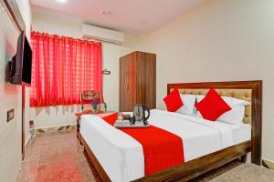Heavens Inn Near Rasoolpura metro station في حيدر أباد: غرفة نوم بسرير كبير ومخدات حمراء