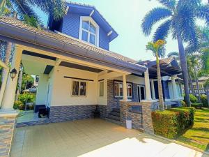 una casa azul y blanca con palmeras en #Nice Private Pool Villa Pattaya, en Nong Prue