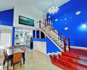una sala de estar con una pared azul y una escalera en #Nice Private Pool Villa Pattaya, en Nong Prue