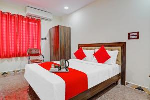 um quarto com uma cama com um cobertor vermelho em Heavens Inn Near Rasoolpura metro station em Hyderabad