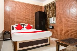 a bedroom with a bed with red pillows at Flagship Hotel Embassy Exhibition Rd in Patna