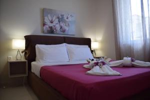 Un dormitorio con una cama con sábanas blancas y flores. en Studio Holiday Kalamata 2, en Kalamata