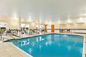 a pool in a hotel with tables and chairs at Fairfield by Marriott Inn & Suites Houston North/Cypress Station in Houston