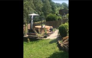 een tuin met een tafel en een parasol bij Pause et vous in Froid-Chapelle