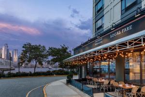 um restaurante com mesas e cadeiras fora de um edifício em Sheraton Lincoln Harbor Hotel em Weehawken