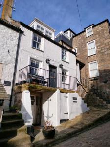 セント・アイヴスにあるAnchorage Guest House, St Ivesのバルコニーと階段付きの大きな白い家です。