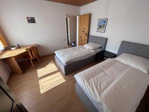 a bedroom with two beds and a table and a desk at FeWo Michistrasse in Forchheim