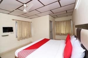 um quarto com uma cama com almofadas vermelhas em Hotel Country Lodge em Dharamshala