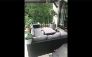 een balkon met een bank en een raam met planten bij Pause et vous in Froid-Chapelle