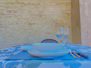 stół z niebieską tkaniną stołową z miskami i kieliszkami do wina w obiekcie CASE BALDELLI LA TERRAZZA w mieście Perugia