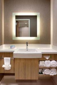 a bathroom with a sink and a mirror and towels at SpringHill Suites by Marriott Moab in Moab