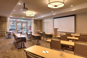 un restaurante con mesas y sillas y una pantalla de proyección en SpringHill Suites by Marriott Moab en Moab