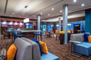 a lobby with chairs and tables and a bar at Courtyard by Marriott Columbus in Columbus