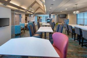une salle à manger avec des tables, des chaises et une télévision dans l'établissement Residence Inn Long Island Hauppauge/Islandia, à Hauppauge