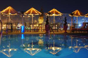 a swimming pool at night with tables and umbrellas at Market Pavilion Hotel in Charleston