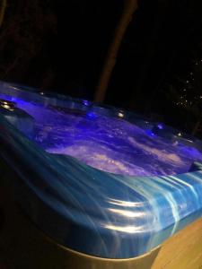 uma piscina com luzes azuis na água à noite em Jax Retreat hot tub and free golf em Felton