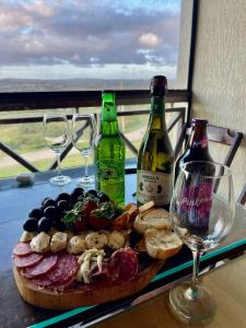 - une table avec une assiette de nourriture et 2 bouteilles de vin dans l'établissement Flat Grande em Hotel Fazenda Monte Castelo - Gravatá - Sairé, à Gravatá