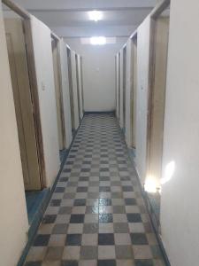 an empty hallway with a checkered floor in a building at Abuzz OxfordCaps, Genome Valley Hyderabad in Hyderabad