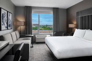 a hotel room with a bed and a large window at TownePlace Suites by Marriott Boston Medford in Medford