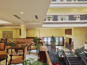 a lobby with tables and chairs in a building at Club Mahindra Snow Peaks Manali in Manāli