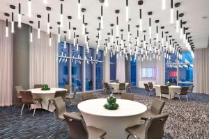 a conference room with tables and chairs and chandeliers at Aloft Chicago Mag Mile in Chicago